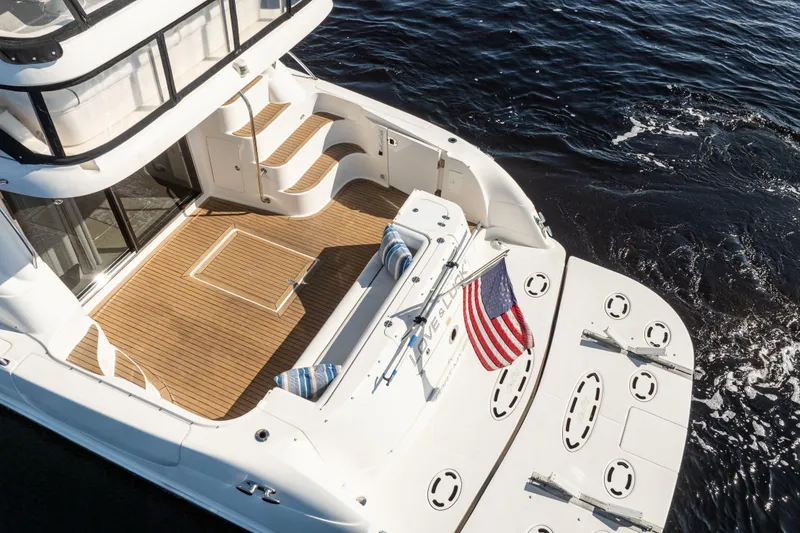 Slide: The Image of 2007 Sea Ray 580 Sedan Bridge yacht with teak deck and American flag on water. - 11