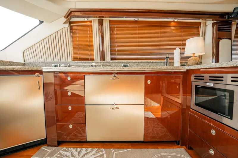 Slide: The Image of Luxurious 2007 Sea Ray 580 Sedan Bridge yacht kitchen with modern appliances and elegant wood finishes. - 29