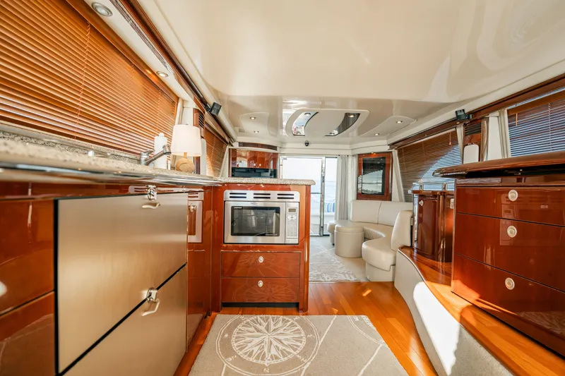 Slide: The Image of Luxurious interior of 2007 Sea Ray 580 Sedan Bridge yacht with modern kitchen and seating area. - 32