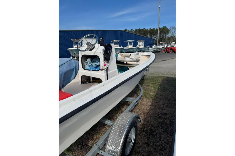 Slide: The Image of 1994 Chincoteague 16 boat on trailer, parked outdoors near blue building. - 10