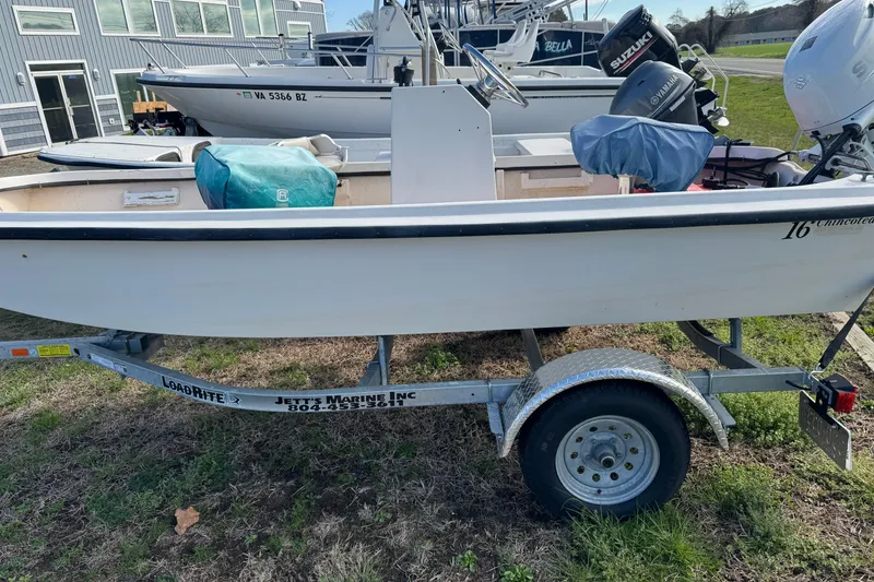 Slide: The Image of 1994 Chincoteague 16 boat on trailer, parked outdoors near other boats. - 12