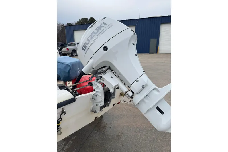 Slide: The Image of 1994 Chincoteague 16 boat with Suzuki outboard motor in a parking lot. - 6