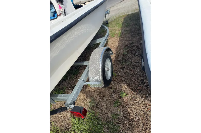 Slide: The Image of Trailer of a 1994 Chincoteague 16 boat parked on grass. - 9