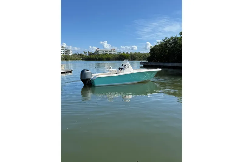 Slide: The Image of 2020 Tidewater 198 CC Adventure boat on calm water under clear blue sky. - 1