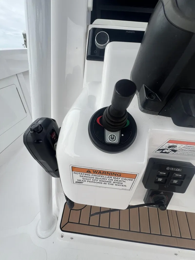 Slide: The Image of 2019 Southport 33 FE boat control panel with joystick and warning labels. - 11