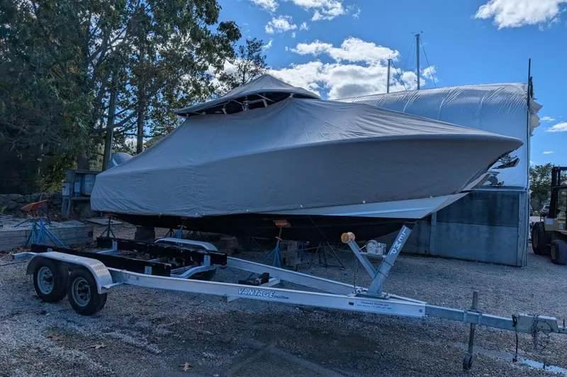 Slide: The Image of Covered 2019 Southport 33 FE boat on trailer, parked outdoors under a blue sky. - 19