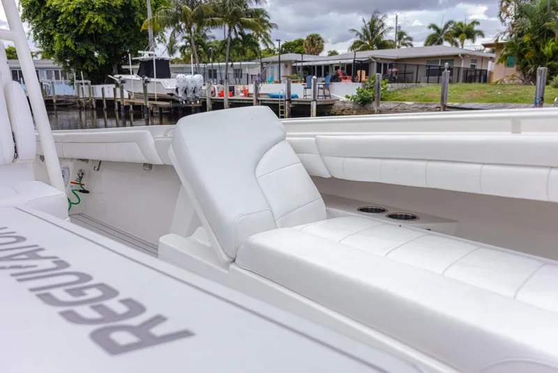 Slide: The Image of 2019 Regulator 34 boat with white seating, docked near waterfront homes. - 23