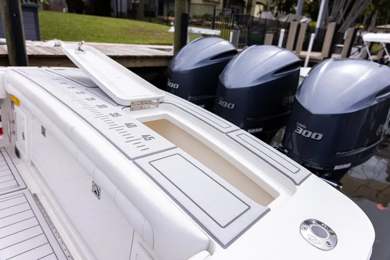 Slide: The Image of 2019 Regulator 34 boat with triple 300 horsepower engines, docked near a grassy area. - 5