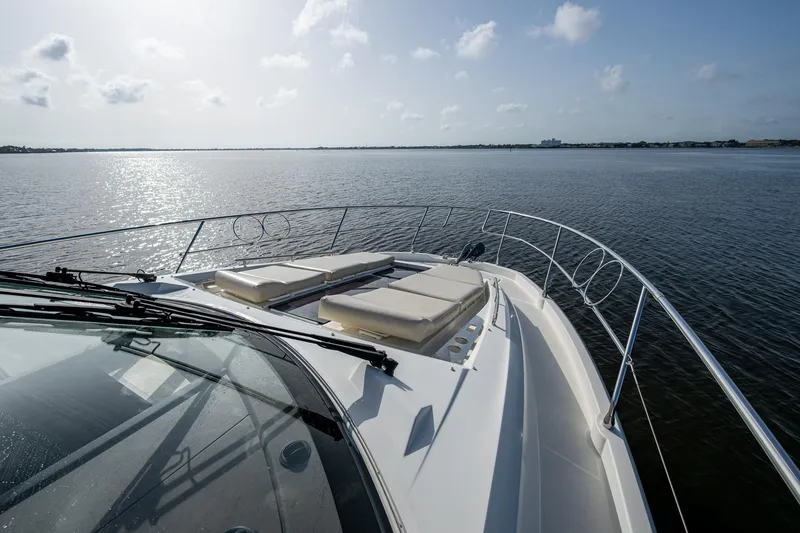 Slide: The Image of 2019 Prestige 460 yacht with sun loungers on deck, cruising on calm waters. - 16