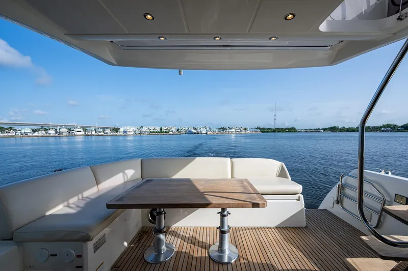 Slide: The Image of Prestige 460 yacht deck with seating and table, overlooking serene water view. - 20