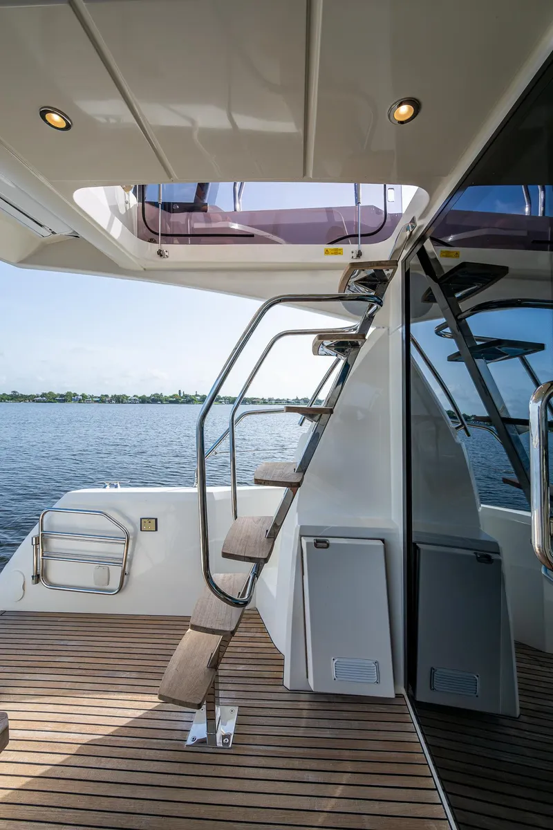 Slide: The Image of 2019 Prestige 460 yacht with elegant interior stairs and scenic water view. - 25