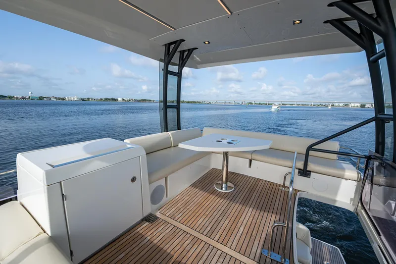 Slide: The Image of Luxurious 2019 Prestige 460 yacht deck with seating, table, and scenic ocean view. - 34