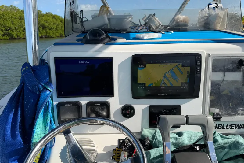 Slide: The Image of 2001 Bluewater 2350 CC boat dashboard with navigation screens and controls. - 11