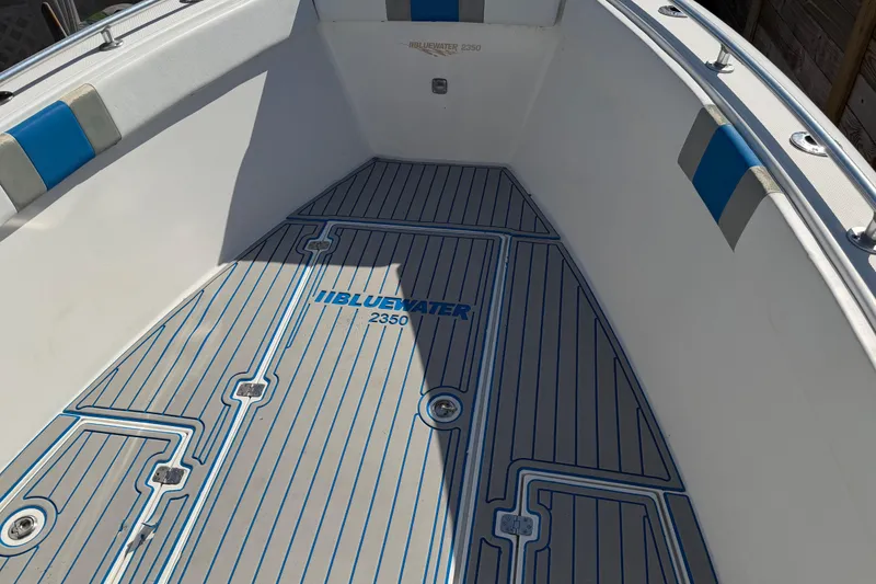 Slide: The Image of 2001 Bluewater 2350 CC boat interior with custom flooring and blue accents. - 16