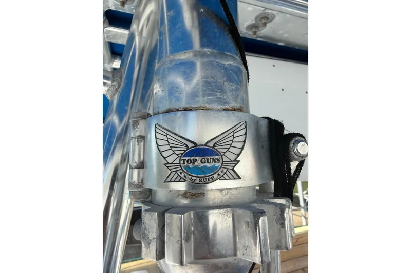 Slide: The Image of Close-up of a 2001 Bluewater 2350 CC boat's metal component with 'Top Guns by Rupp' logo. - 20