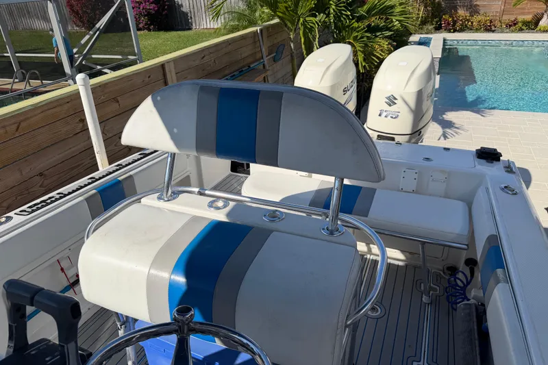 Slide: The Image of 2001 Bluewater 2350 CC boat interior with dual Suzuki engines by a poolside. - 21