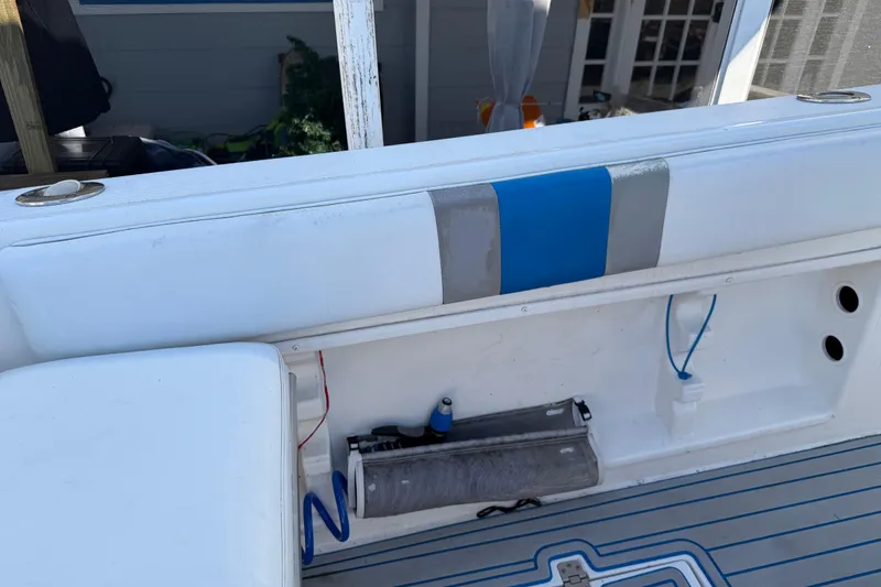 Slide: The Image of 2001 Bluewater 2350 CC boat interior with white and blue seating, storage compartment. - 27