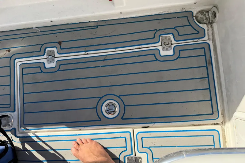 Slide: The Image of Deck of 2001 Bluewater 2350 CC boat with foot visible. - 28