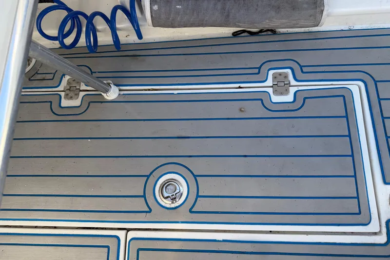 Slide: The Image of Deck of 2001 Bluewater 2350 CC boat with blue and gray non-slip surface. - 29
