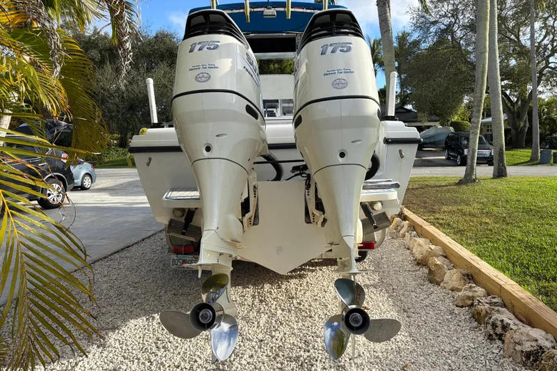Slide: The Image of 2001 Bluewater 2350 CC boat with twin 175 horsepower outboard engines on gravel driveway. - 3