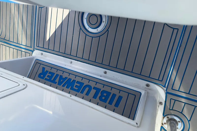 Slide: The Image of Deck of 2001 Bluewater 2350 CC boat with logo and blue accents. - 33