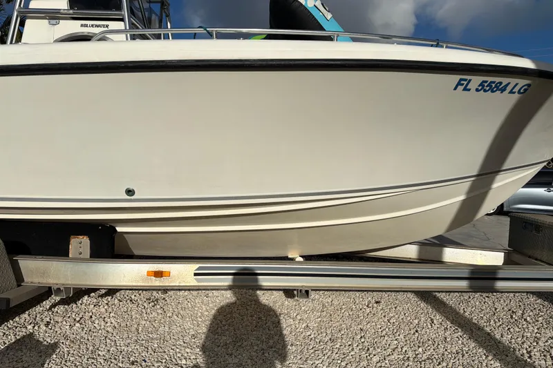 Slide: The Image of 2001 Bluewater 2350 CC boat on trailer, side view, with registration number visible. - 4