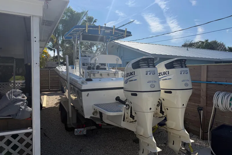 Slide: The Image of 2001 Bluewater 2350 CC boat with dual Suzuki 175 outboard engines in a driveway. - 6