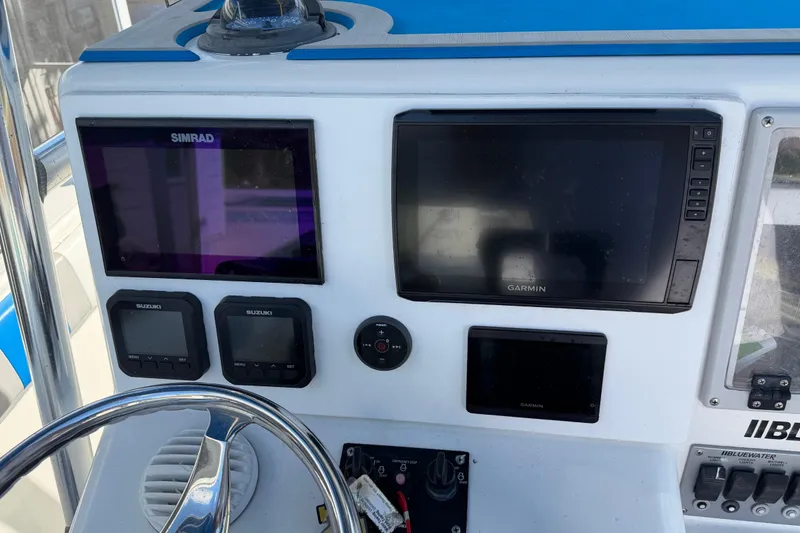 Slide: The Image of Center console of 2001 Bluewater 2350 CC with Simrad and Garmin displays. - 9