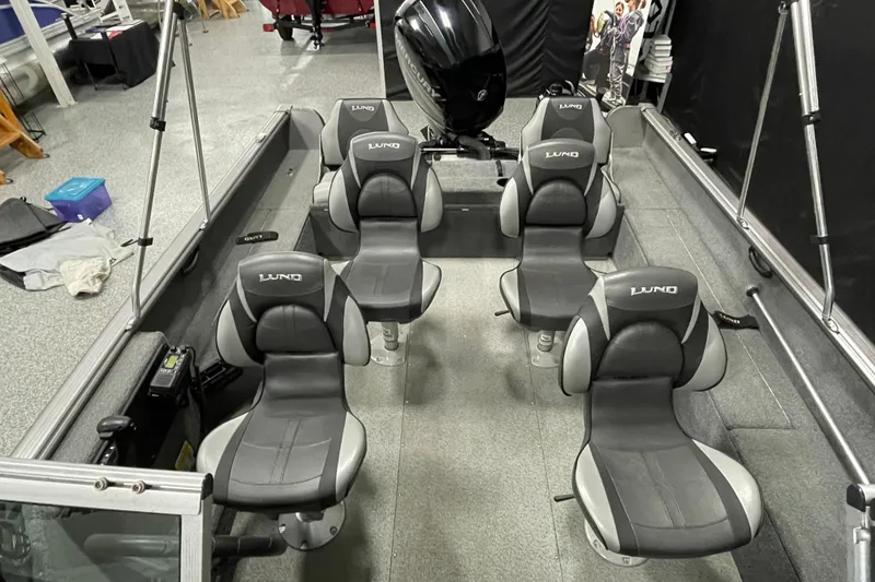 Slide: The Image of 2018 Lund 1875 Impact Sport boat interior with five gray seats and motor. - 11