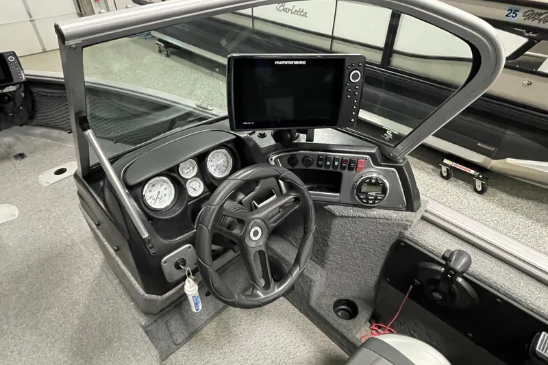 Slide: The Image of 2018 Lund 1875 Impact Sport boat dashboard with steering wheel and Humminbird display. - 12
