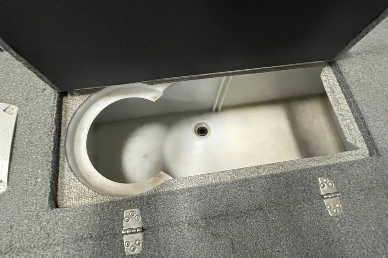 Slide: The Image of 2018 Lund 1875 Impact Sport boat storage compartment with open lid and drain. - 9