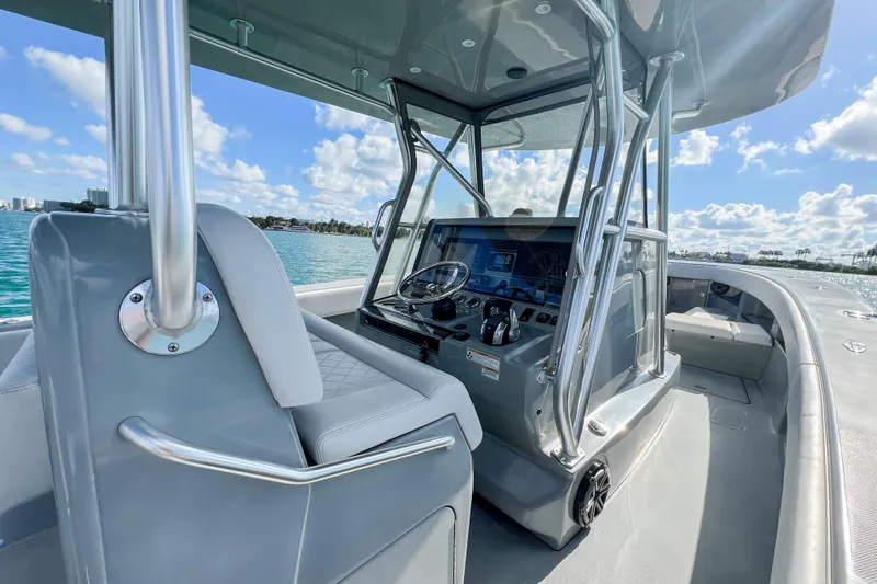 Slide: The Image of 2018 SeaVee 390Z boat interior with helm, steering wheel, and ocean view. - 9