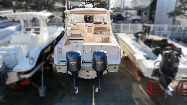 Slide: The Image of 2013 Grady-White Freedom 335 boat with dual outboard engines, docked at a marina. - 14