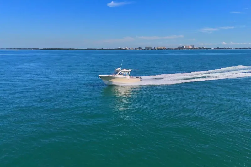 Slide: The Image of 2013 Grady-White Freedom 335 boat cruising on open blue water. - 2