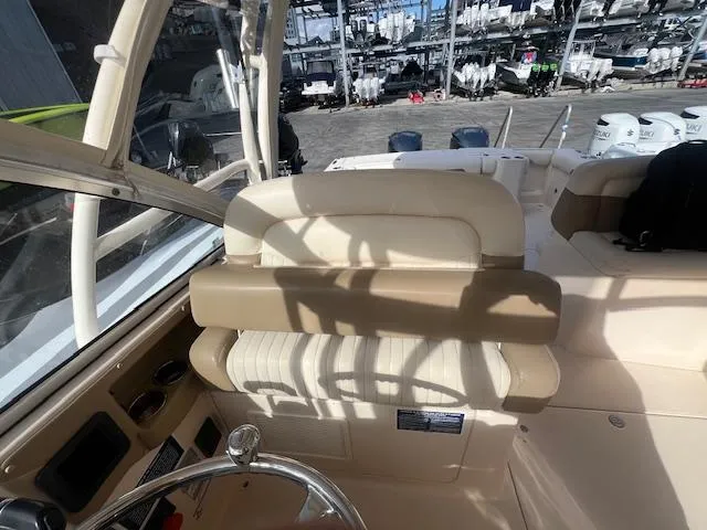 Slide: The Image of Interior of 2013 Grady-White Freedom 335 boat with beige seating and steering wheel. - 29