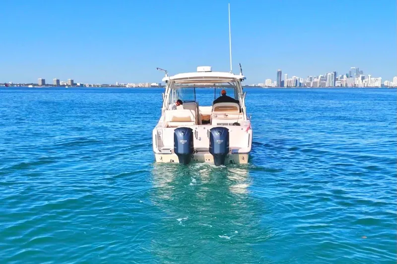 Slide: The Image of 2013 Grady-White Freedom 335 boat on blue water with city skyline in background. - 3