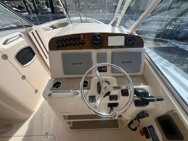 Slide: The Image of 2013 Grady-White Freedom 335 boat dashboard with Garmin navigation systems and steering wheel. - 30