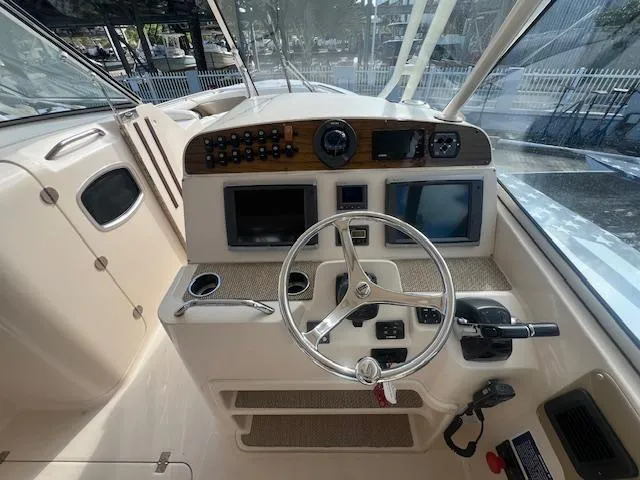 Slide: The Image of 2013 Grady-White Freedom 335 boat dashboard with steering wheel and navigation controls. - 31
