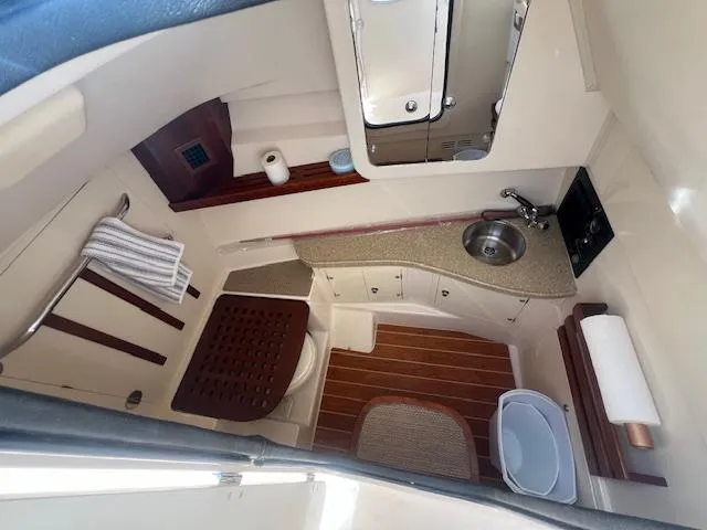 Slide: The Image of 2013 Grady-White Freedom 335 boat bathroom with sink, toilet, and wooden accents. - 34