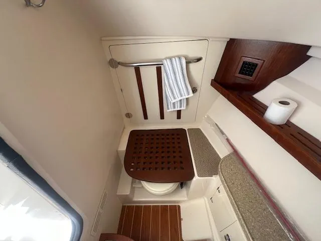 Slide: The Image of 2013 Grady-White Freedom 335 boat bathroom interior with wooden accents and towel rack. - 35
