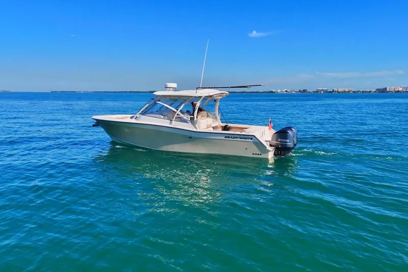 Slide: The Image of 2013 Grady-White Freedom 335 boat cruising on clear blue water under a sunny sky. - 4