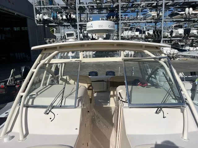 Slide: The Image of 2013 Grady-White Freedom 335 boat docked in a marina with multiple vessels. - 40