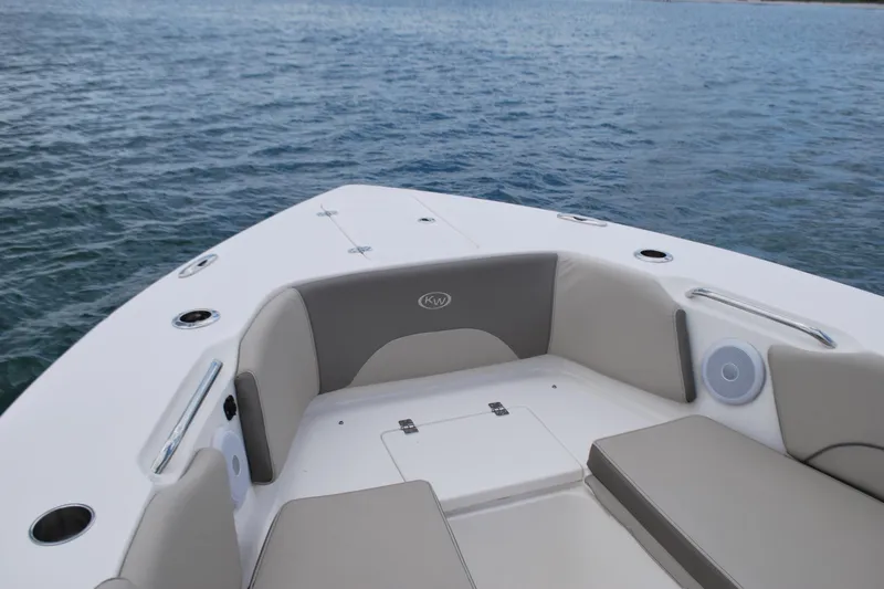 Slide: The Image of 2022 Key West 263 FS boat interior with cushioned seating on calm water. - 7