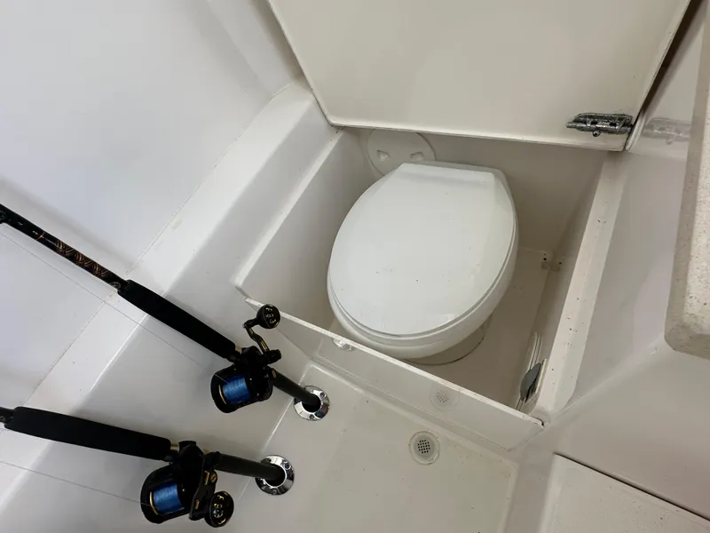 Slide: The Image of 2006 Island Runner 35 boat interior with fishing rods and compact toilet. - 36