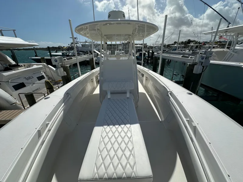 Slide: The Image of 2006 Island Runner 35 boat with white seating, docked at a marina under a sunny sky. - 49
