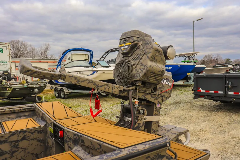 Slide: The Image of 2026 Gator Tail 17/50 MID-DECK SAVAGE SERIES boat with camo design, parked outdoors. - 12