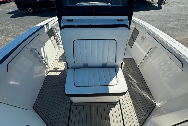 Slide: The Image of 2023 Yamaha Boats 255 FSH Sport E interior with cushioned seating and sleek design. - 12