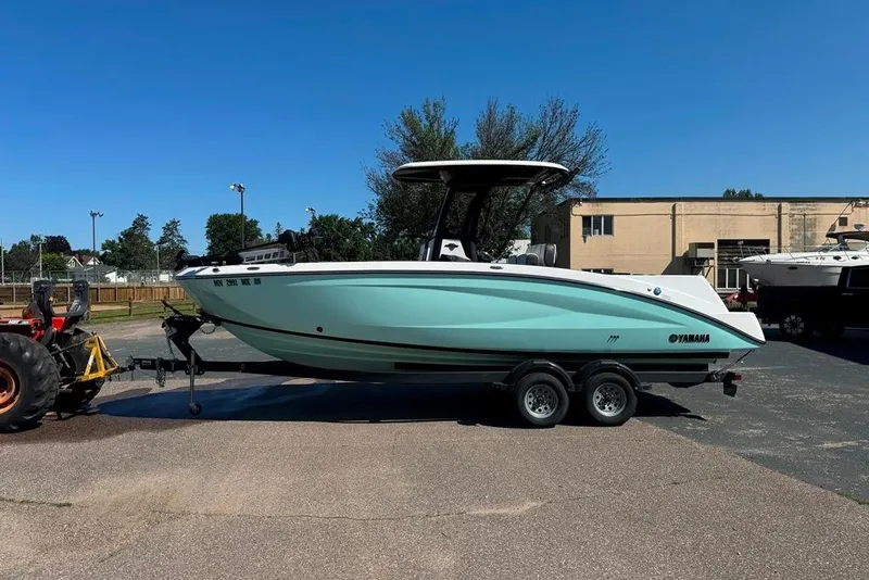 Slide: The Image of 2023 Yamaha Boats 255 FSH Sport E on trailer, parked outdoors under clear sky. - 15
