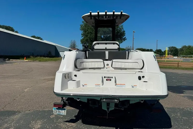 Slide: The Image of 2023 Yamaha Boats 255 FSH Sport E, rear view, parked outdoors on a sunny day. - 17