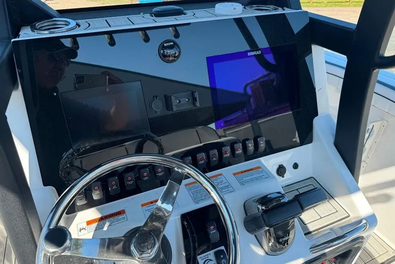 Slide: The Image of 2023 Yamaha Boats 255 FSH Sport E dashboard with steering wheel and controls. - 5